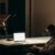 Stay Updated - Man in Black and White Plaid Dress Shirt Sitting on Chair in Front of Macbook
